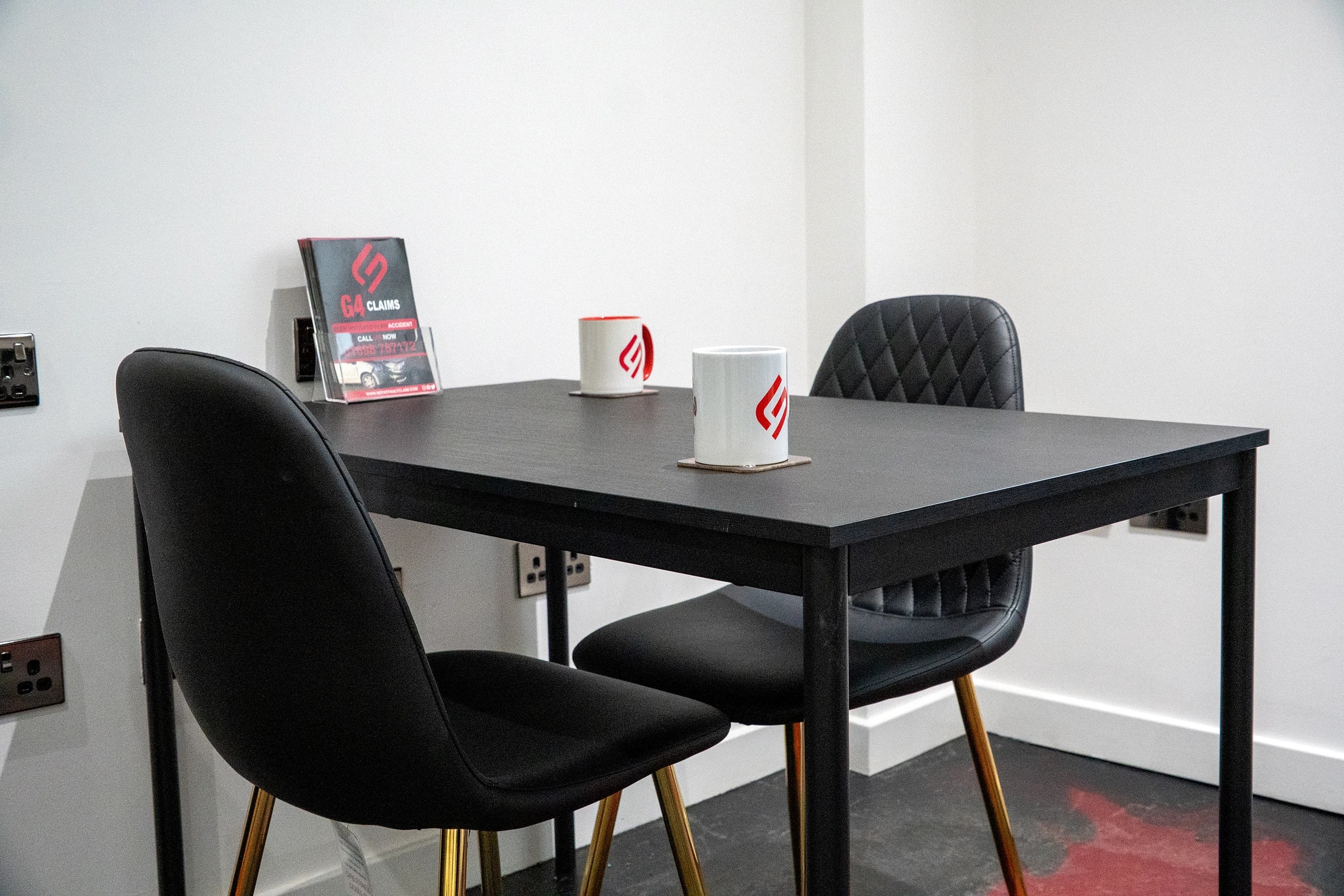 The meeting room table at Claims HQ with two G4 Claims mugs and a G4 Claims leaflet