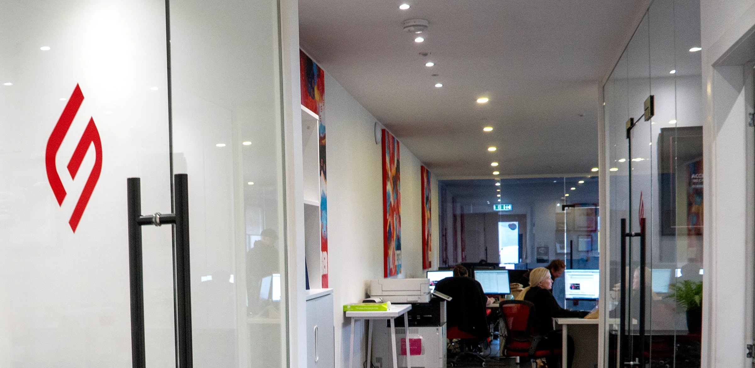 Inside Claims HQ in Wishaw: the glass entrance with the G4 logo and the corridor to the open-plan office, where our team is at work