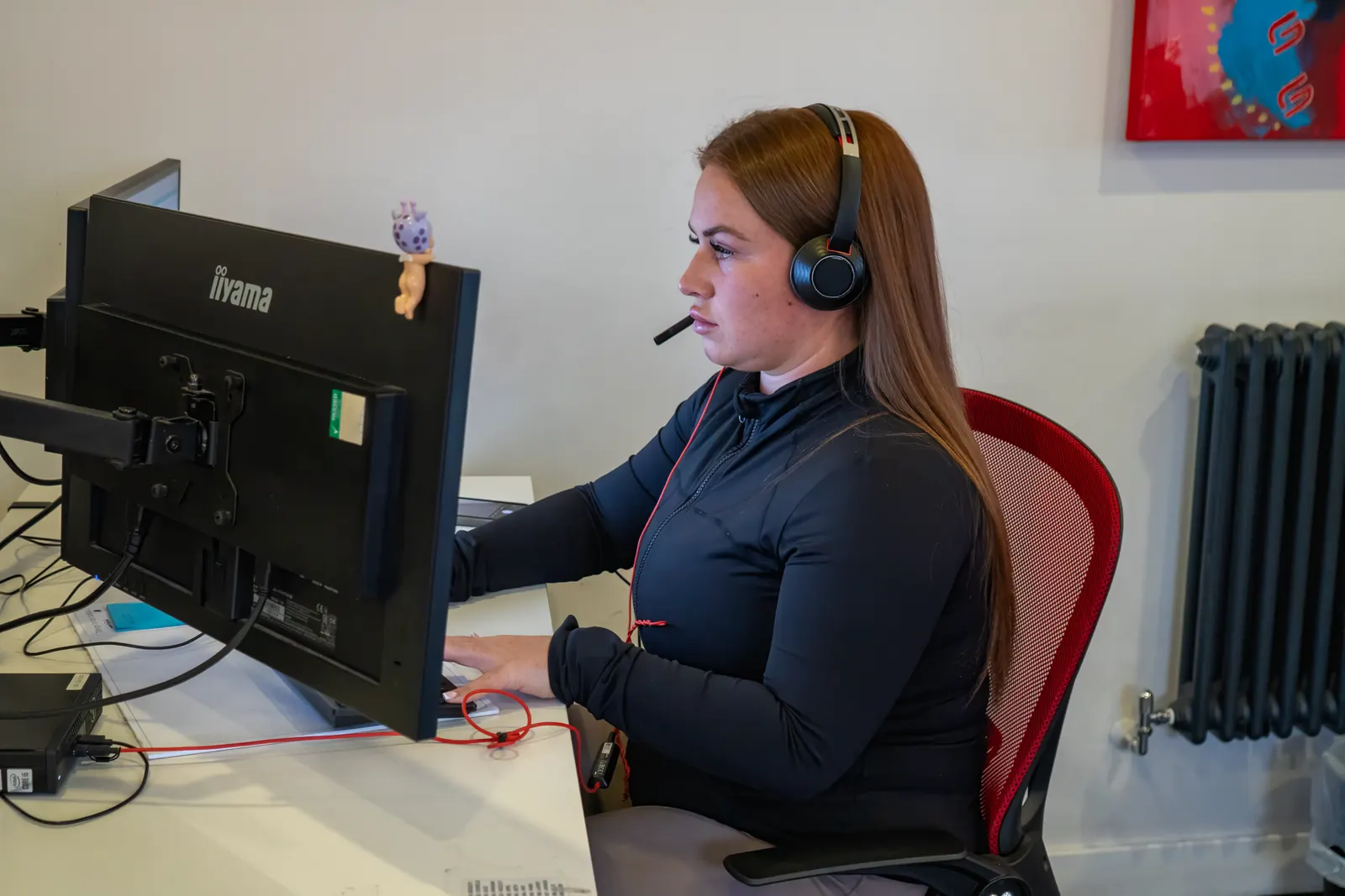 A G4 Claims team member with a headset working on a claim at her computer